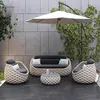 An outdoor furniture set on a patio with a tiled wall and greenery. Produktbild-Vorschau