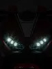Close-up of the front of a red and white Honda motorcycle, focusing on the headlights and the Honda logo. Anteprima dell’immagine prodotto