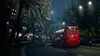 A red double-decker bus drives down a city street at night, with palm trees and tall buildings lining the road. Produktbild-Vorschau