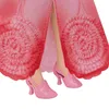 Close-up of a doll's legs wearing pink shoes and a pink dress with floral patterns. Voir les images du produit