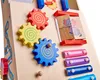 Close-up of a wooden educational toy with gears, xylophone bars, and puzzle pieces featuring elephants. Náhled obrázku produktu