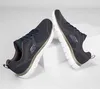 A pair of navy Skechers shoes are displayed on white blocks against a white background. Produktbild-Vorschau
