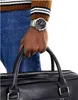 A person's hand wearing a watch and holding a bag. Náhled obrázku produktu