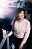 A young woman with headphones is holding a pink shaker bottle and smiling. Voir les images du produit