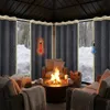 Cozy outdoor seating area with a fire pit and snow outside, protected by thick curtains. Voir les images du produit