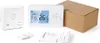 A smart thermostat and its accessories are laid out on a white surface, with a cardboard box in the background. Podgląd zdjęcia produktu