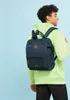 A person wearing a green hoodie and black jeans is carrying a navy blue backpack. Voir les images du produit