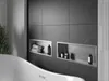 A modern bathroom with a bathtub and tiled walls, featuring built-in shelves with toiletries and towels. Náhled obrázku produktu