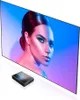 A projector screen displaying a woman's face with dramatic lighting, and a small projector in the foreground. Produktbild-Vorschau