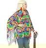 A woman wearing a colorful tie-dye poncho and headband, holding a guitar. Produktbild-Vorschau