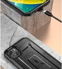 A close-up shot of a black smartphone case with a kickstand, resting on textured stone surfaces. Another smartphone is visible in the background, being charged. Produktbild-Vorschau