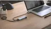 A USB hub connected to a laptop on a wooden desk. Anteprima dell’immagine prodotto