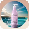 A bottle of Arkemusa Keratin Regenerating Conditioner is placed in a pool with water splashing around it. Náhled obrázku produktu