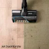 A vacuum cleaner head is shown cleaning two different surfaces: a wooden floor with dirt and a carpet with dirt. Anteprima dell’immagine prodotto