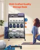 A woman is doing yoga in front of a storage rack filled with gym equipment. Náhľad obrázku produktu