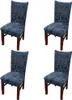 Four dining chairs with blue leaf-patterned slipcovers and brown wooden legs, arranged in a grid on a white background. Náhled obrázku produktu