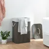 A laundry basket with clothes and a lid in a room. Podgląd zdjęcia produktu