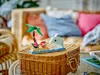 A small LEGO® set of a tropical island with a dolphin jumping out of the water, placed on a wicker basket. Náhled obrázku produktu