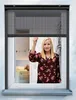 A woman is shown through a window with a screen. Produktbild-Vorschau