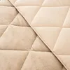 A close-up view of a beige quilted blanket, showing two different textures on each side. Produktbild-Vorschau