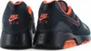A close-up rear view of two black Nike Air Max 180 sneakers with orange accents. Náhľad obrázku produktu