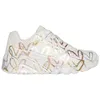 A side view of a white sneaker with a heart pattern. Voir les images du produit