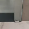 A close-up view of the bottom corner of a frosted glass sliding door and its floor guide. Produktbild-Vorschau