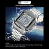 A silver digital watch with a metal band is shown in a dynamic, watery environment with a city skyline in the background. Náhled obrázku produktu