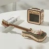 A wooden model of an electric guitar and amplifier are displayed on a white surface. Voir les images du produit