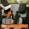 Close-up of a child car seat with layered padding and an orange arrow pointing upwards, highlighting features. Produktbild-Vorschau