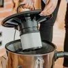 A person is holding a filter over a vacuum cleaner. Produktbild-Vorschau