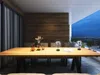 A dining table and chairs on a balcony with a city view at dusk. Produktbild-Vorschau