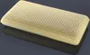 A yellow pillow with many small holes is shown on a reflective dark gray surface. Produktbild-Vorschau