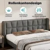 A close-up view of a bed with a gray upholstered headboard and pillows. Produktbild-Vorschau