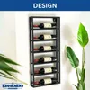 A black metal wine rack mounted on a white wall, holding six bottles of wine. A green plant is visible to the right, and a logo is in the bottom left corner. Náhľad obrázku produktu