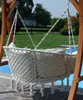 A hammock chair with cushions is suspended from a wooden frame next to a swimming pool. Produktbild-Vorschau