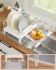 A white dish rack with dishes, glasses, and fruit placed on it, set over a kitchen sink. Produktbild-Vorschau