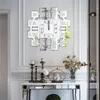 A decorative wall clock with Roman numerals is mounted on a wall above a console table with decorative items. Anteprima dell’immagine prodotto