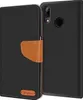A black flip case for a Huawei P20 Lite phone, with a brown leather strap and a small brown logo on the front. Podgląd zdjęcia produktu