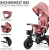 A close-up view of a pink children's tricycle, highlighting safety features and accessories. Produktbild-Vorschau