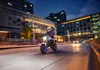 A person riding a motorcycle at night in a city. Náhľad obrázku produktu