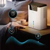A white dehumidifier is placed on a nightstand next to a bed with pillows and a blanket. There are graphic overlays indicating features like sleep mode, quiet operation, and noise level. Produktbild-Vorschau