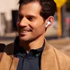 A man wearing earbuds and a jacket outdoors. Voir les images du produit
