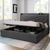 A modern bedroom with a grey upholstered storage bed with the mattress lifted to reveal storage compartments. Produktbild-Vorschau