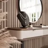 A vanity table with jewelry displayed on a bust, a mirror, and makeup accessories. Produktbild-Vorschau