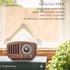 A vintage-style radio sits on top of books, with a window and greenery in the background. Produktbild-Vorschau
