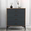 A chest of drawers with four drawers, set against a white paneled wall. Náhled obrázku produktu
