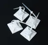 Four white cable tie mounts with integrated cable ties are arranged on a black surface. Produktbild-Vorschau