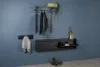 A modern entryway setup with a wall-mounted coat rack, a shoe cabinet with a flip-down door, and a towel hanging on a hook. Produktbild-Vorschau