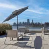 A rooftop patio with chairs and an umbrella overlooking a city skyline. Produktbild-Vorschau
